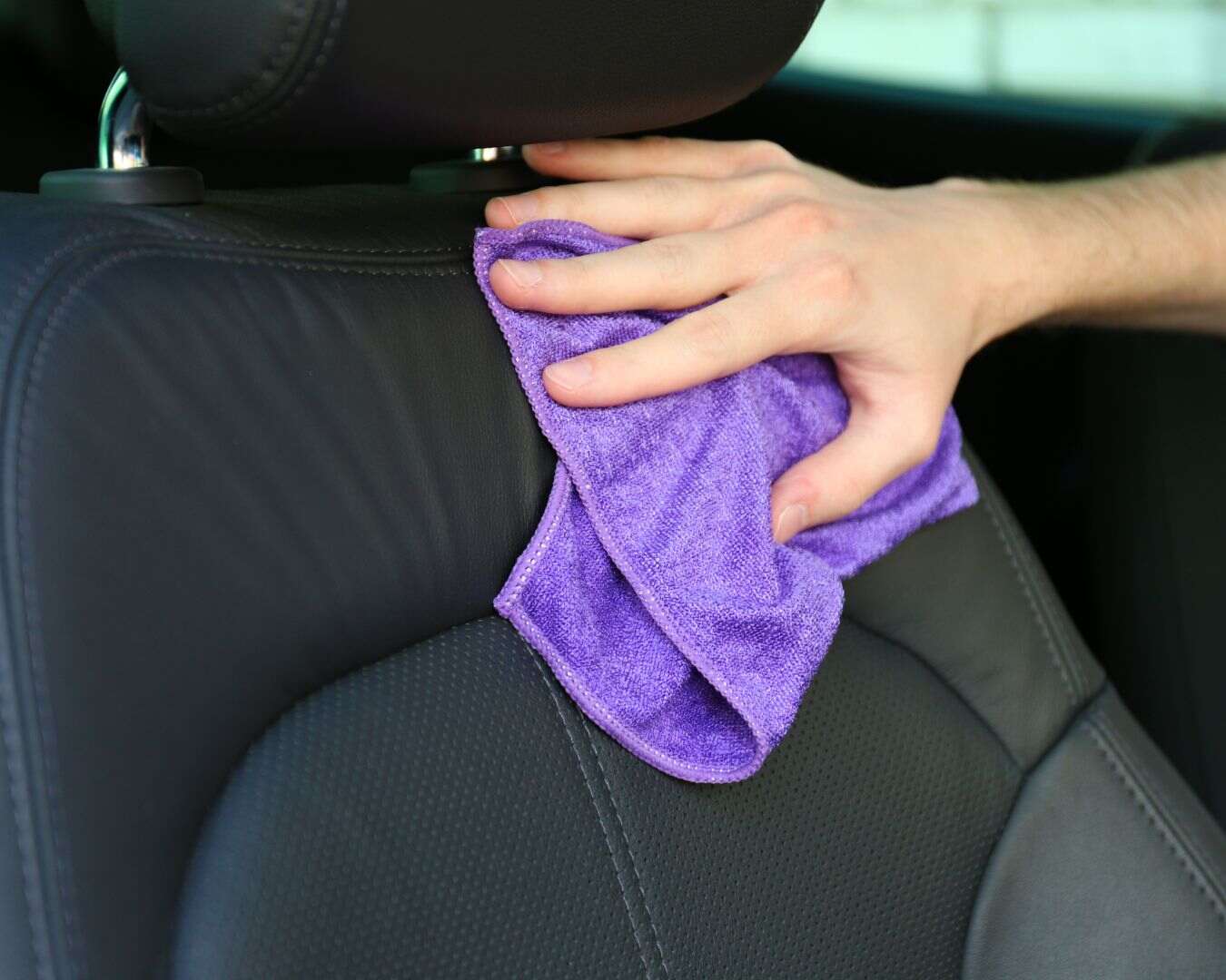 Sedile di un auto che viene pulito con un panno